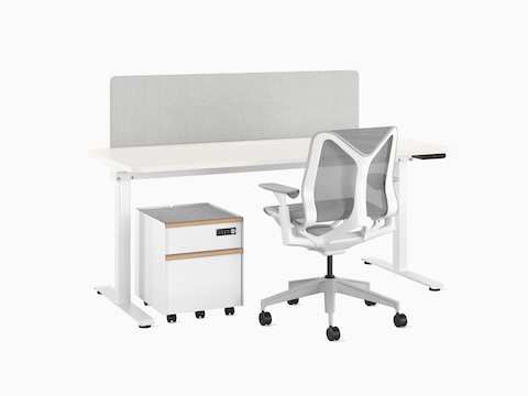 A white, freestanding Nevi Sit-to-Stand Desk with a grey fabric screen; white Trac pedestal with wooden drawer pulls; and white, low-back Cosm Chair with Mineral suspension.