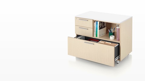 A Tu storage unit with two box drawers, a lateral file, and an open shelf in a light woodgrain finish. A Tu storage unit with two box drawers, a lateral file, and an open shelf in a light woodgrain finish.