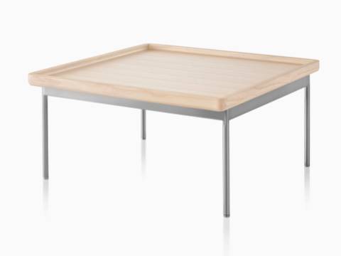 带角度的视图：搭配浅色木纹饰面和银白色金属底座的长方形Tuxedo桌子。