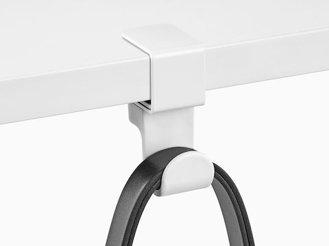 A black strap loops over a Ubi Bag Hook clamped onto a work surface.