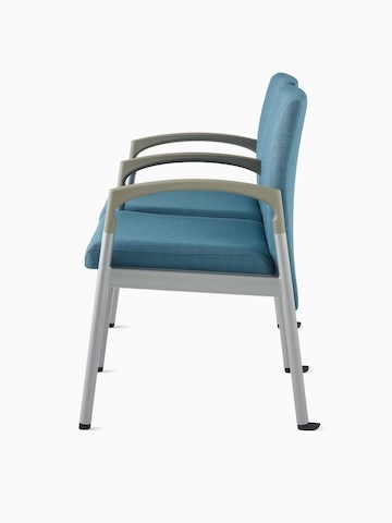 Side view of Valor two-seat multiple seating with intervening arms and legs in a blue upholstery, silver frame, and pewter armcaps on white sweep.