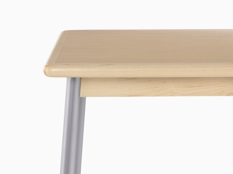 Close view of a steel leg and wood edge on a Valor Table.