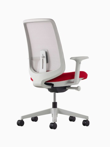 Ein Verus Stuhl mit Membran-Rückenlehne, roter Sitzfläche und Rahmen in Mineral, im schrägen Winkel betrachtet.