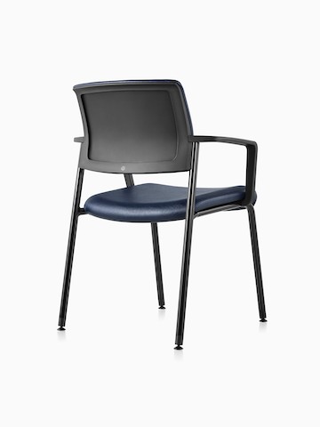 Vista três quartos de uma cadeira para visitantes Verus preta, com braços estofados com vinil azul e encosto estofado em preto.