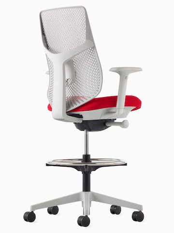 Ein weißer Verus Hocker mit roter Sitzfläche und Triflex Rückenlehne, im schrägen Winkel betrachtet.
