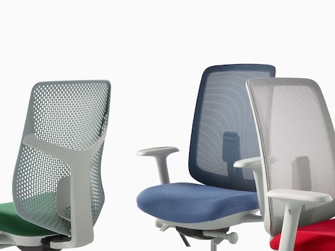 Nahansicht von drei Verus Stühlen: einem mit grüner Triflex Rückenlehne, einem mit blauer Sitzfläche und Membran-Rückenlehne und einem mit grauer Membran-Rückenlehne und roter Sitzfläche.