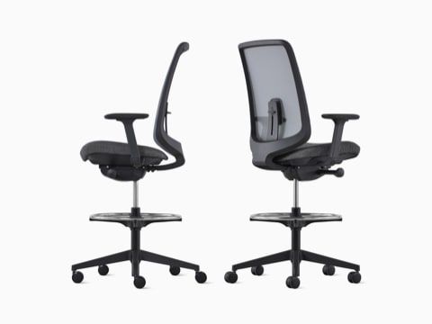 Dos taburetes Verus en negro con respaldo de suspensión vistos desde el ángulo lateral y posterior. Dos taburetes Verus en negro con respaldo de suspensión vistos desde el ángulo lateral y posterior.