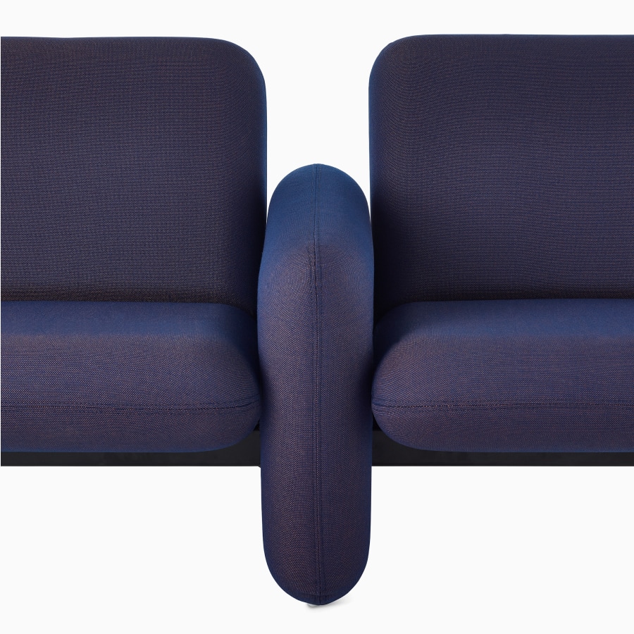 Visão detalhada aproximada da almofada lateral, assento e encosto de um sofá de 5 lugares do Grupo de Sofás Modulares Wilkes em azul escuro.