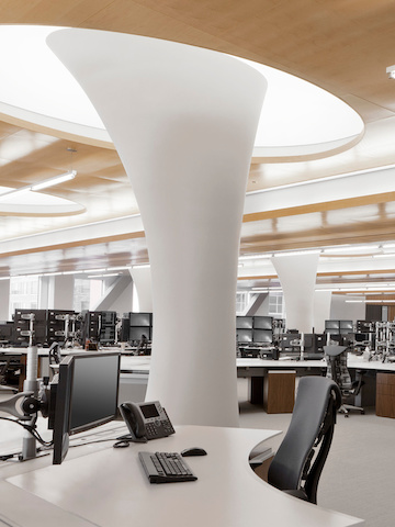 An open office featuring black Embody office chairs and monitor arms supporting multiple screens.