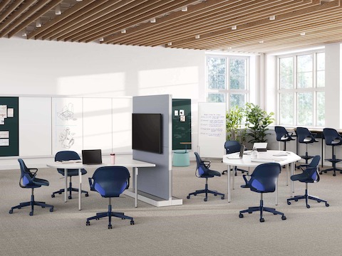 蓝色的Zeph座椅和凳子，搭配一系列工作空间系列的产品，包括Workshop（工作坊）设置中的OE1共享桌、OE1敏捷墙和OE1小型会议桌。