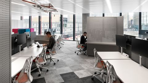 Environnement de bureau avec des bureaux Ratio, des supports d'écran Lima et des sièges Sayl.