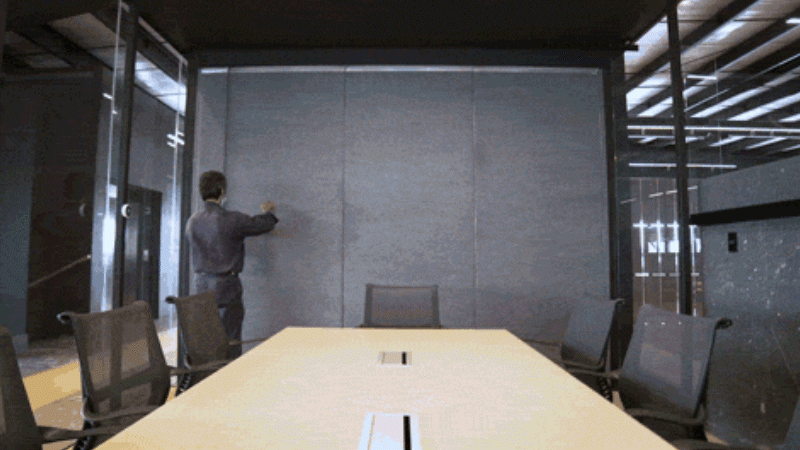 Ein Brinco-Mitarbeiter bewegt Stellwände, um den Besprechungsraum zu verkleinern.