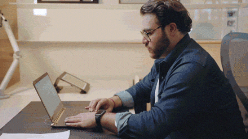 A man seated at a Canvas adjustable-height table working on his laptop. A man seated at a Canvas adjustable-height table working on his laptop.