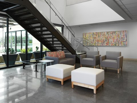 Lobby waiting area with Nemschoff Brava Classic Armchair in gray and Nemschoff Brava Classic Multiple Seating in a gray seat and multicolored back with Nemschoff Brava Platform Bench in soft white seat and wood base with a Nemschoff Palisade Side Table in a white top and silver base.