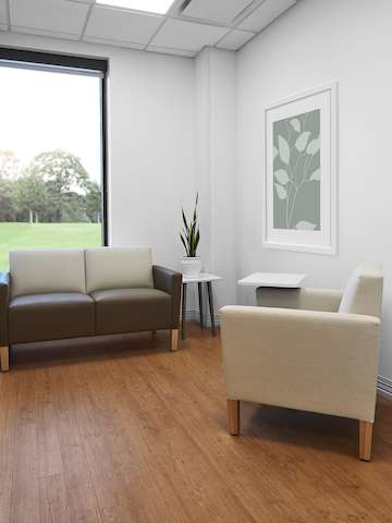 Patient consultation room with Nemschoff Brava Classic arm chair in beige and Brava Classic Multiple Seating in a brown seat and beige back with a Nemschoff Palisade Mobile Table and a Nemschoff Palisade Side Table.