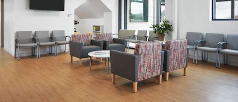 Waiting area with Nemschoff Brava Classic in gray seats and multicolored backs with Nemschoff Valor Side Chairs and Plus Chairs in gray with a Palisade Coffee Table in a white top and silver legs.