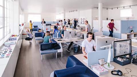 Staff work inside a shared office setup with Public Office Landscape furnishings. 