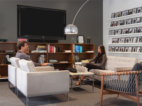 A man and a woman meeting in a casual lounge space.