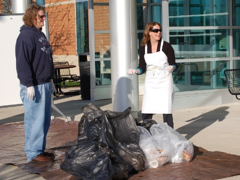 Two people sort through trash in search of recyclable materials at Grand Valley State University. Two people sort through trash in search of recyclable materials at Grand Valley State University.