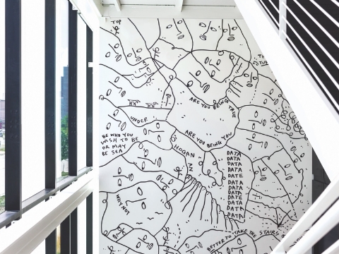 A large piece of art hangs inside of an office entrance. A large piece of art hangs inside of an office entrance.