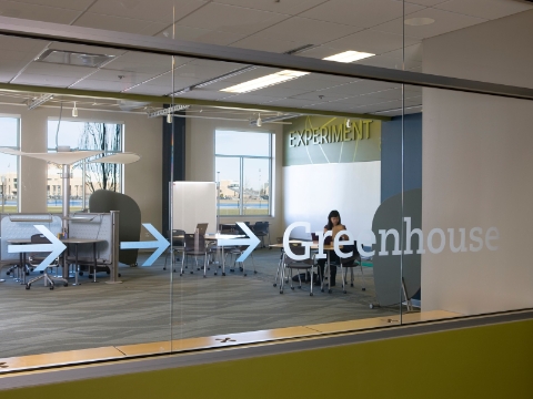 An outside view of the Greenhouse shows a glimpse of Caper chairs and Intersect tables. 