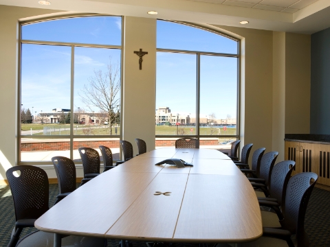 A formal conference room with an Intersect table and Caper chairs provides a view of the Notre Dame campus.