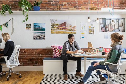 Los empleados de la oficina interactúan juntos mientras están sentados en los muebles de Cove Setting.