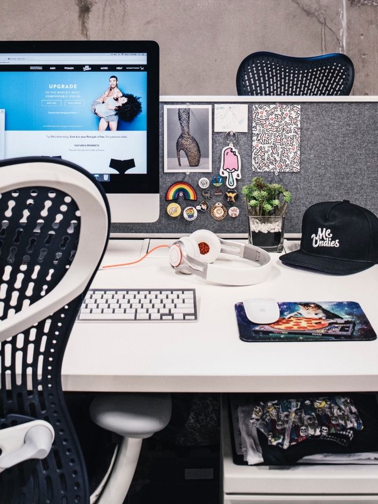 An office desk setup shows a computer and various personal items as decor.