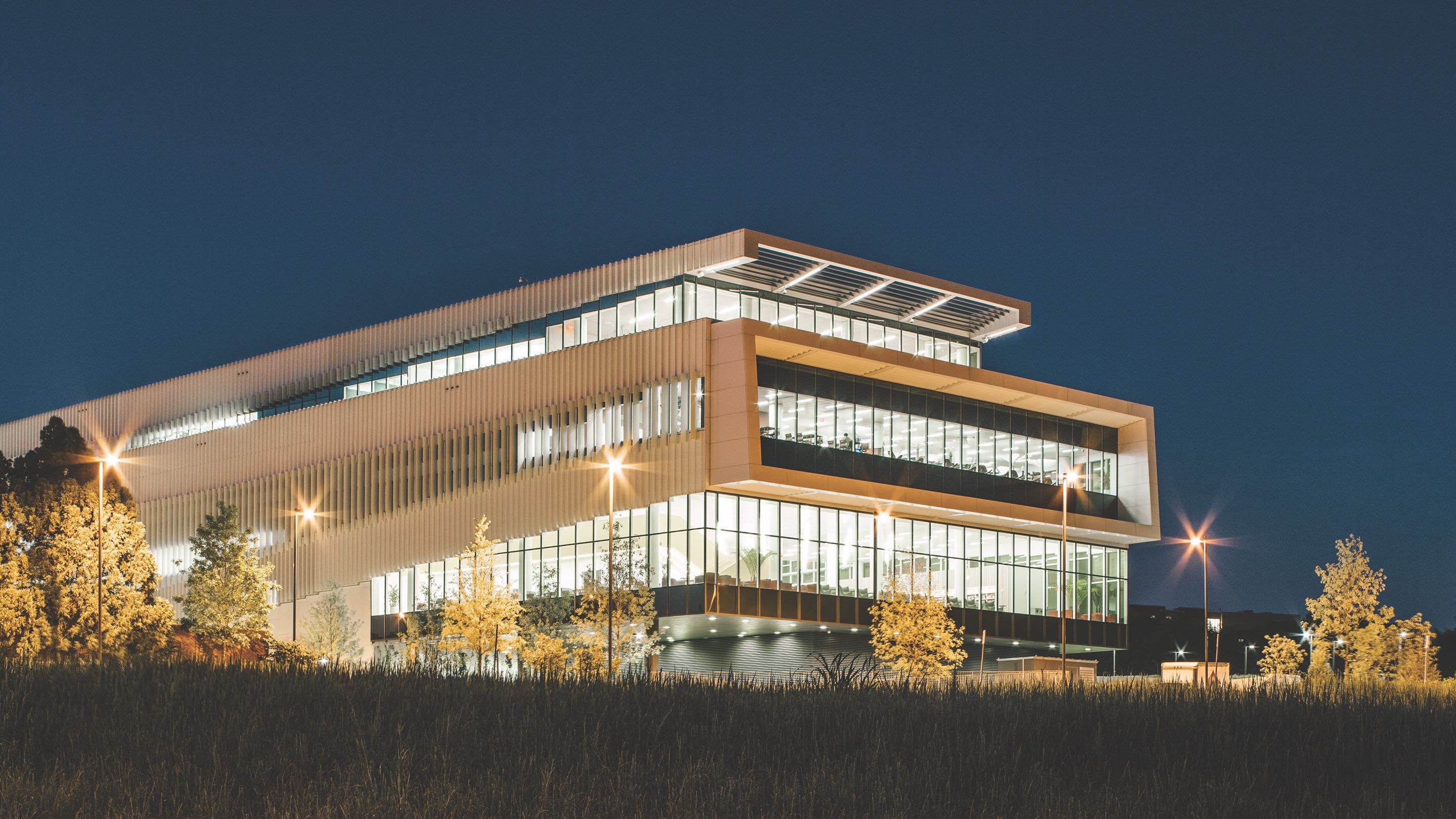 An exterior view of a campus library at night. 