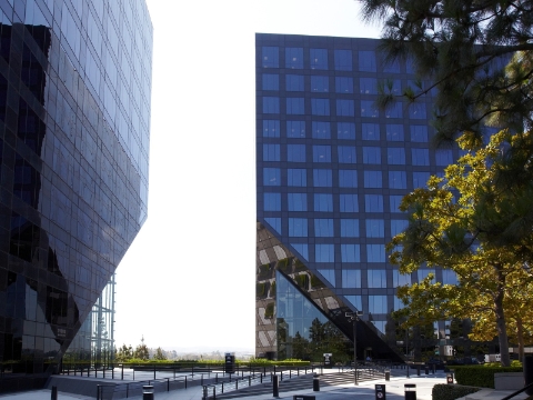 An outside view of two office buildings with a shared walkspace in the center. 
