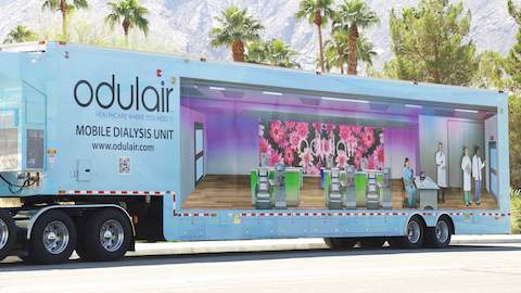 A mobile dialysis unit inside of a trailer sits parked by a curb.