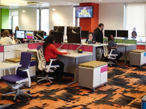 Office employees work while using Flo monitor supports at their desks. Office employees work while using Flo monitor supports at their desks.