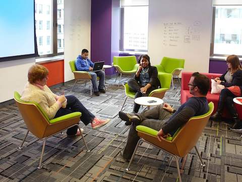 Office employees hold a discussion inside a collaborative space. Office employees hold a discussion inside a collaborative space.