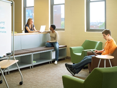 Students study and converse while seated in different furnishings throughout a classroom area. Students study and converse while seated in different furnishings throughout a classroom area.