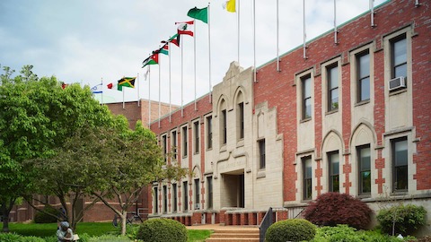 The outside of a Saint Louis University campus building with flags from several nations. 