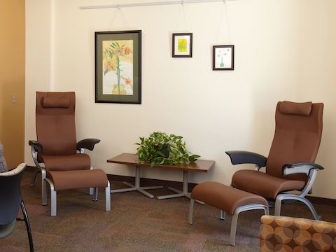 Nala patient chairs and ottomans sit inside a waiting area. 