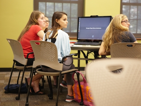 Students listen to an instructor while seated in Caper chairs. 