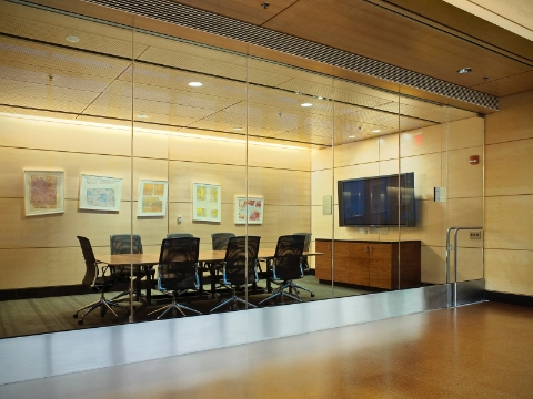 An enclosed conference room inside the Ross Building features a classic Eames table.