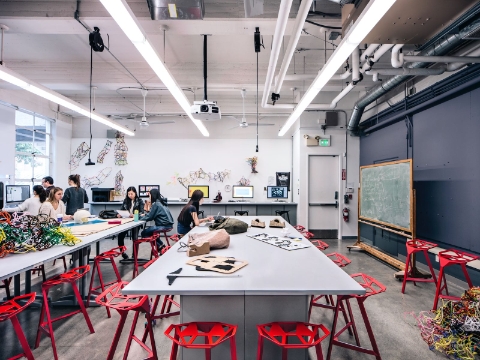 Students work on 3-D art projects inside of a college classroom setting. 