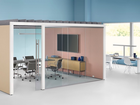 An enclosed Overlay meeting room with two glass walls and two laminate walls with a conference table and four chairs inside. An enclosed Overlay meeting room with two glass walls and two laminate walls with a conference table and four chairs inside.