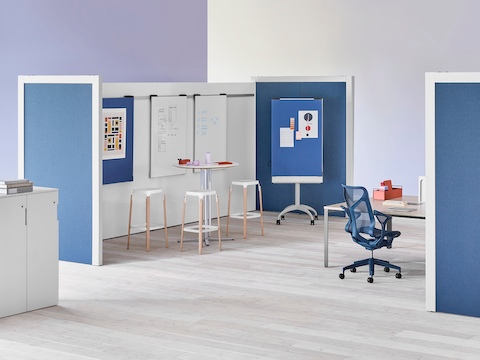 Dos divisores de ambiente Overlay entrecruzados con mesas y sillas en el medio y pizarras para marcadores en el interior y género azul en el exterior.
