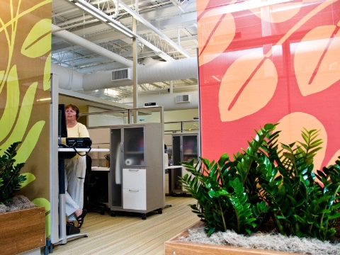 A call center employee opts to work at a standing desk rather than sitting. 