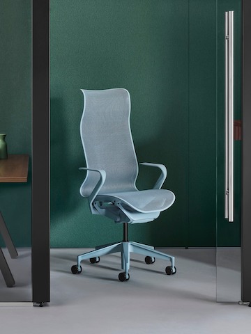 Two enclosed Overlay rooms with a walnut fixed-height desk, credenza and light blue Cosm chair in one room and a walnut Motia height-adjustable desk and light blue Cosm chair in the other.