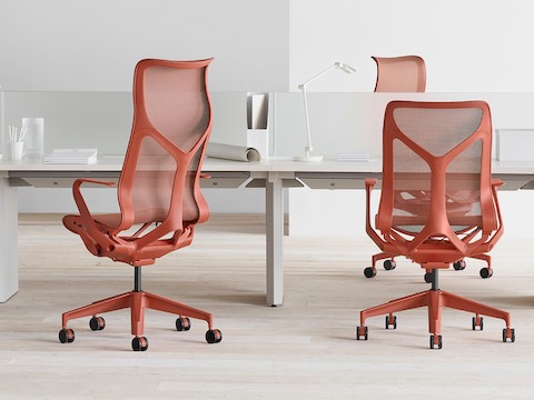 Cosm chairs in red around a workstation. Cosm chairs in red around a workstation.