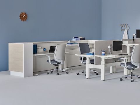 A care team environment with a white and wood laminate prefab Commend Nurses Station, Verus Chairs, Renew Link, and Renew Sit-to-Stand Tables.