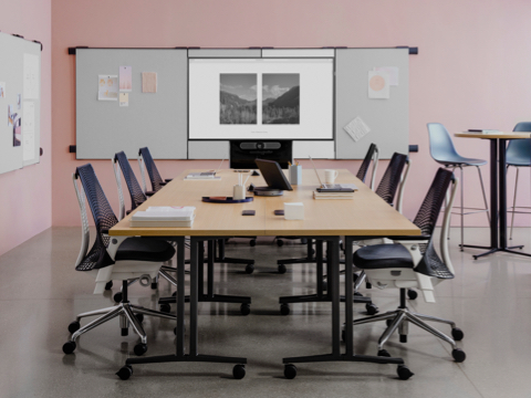 Meeting tables in a Workshop Setting with locker storage and project work pinned on boards attached to the walls.