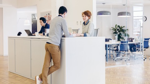 A duo of employees at Harry’s stand and chat at a row of Meridian storage, which serves double time as a work surface.