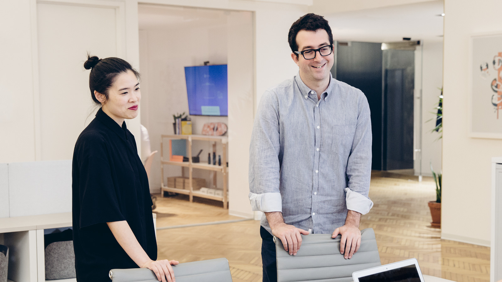 Two employees chat in a conference room at Harry’s, a men’s grooming company. The image confirms that the company now has a variety of collaborative spaces that are easy to find and use.