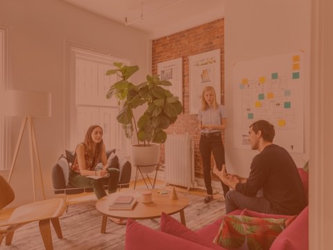 Three people have a dicussion in an office designed based on research on people's needs and daily work activities.