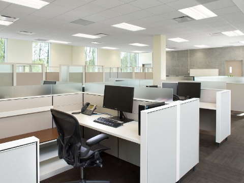 Several open workstations, outfitted with Aeron chairs, computers, and phones. 